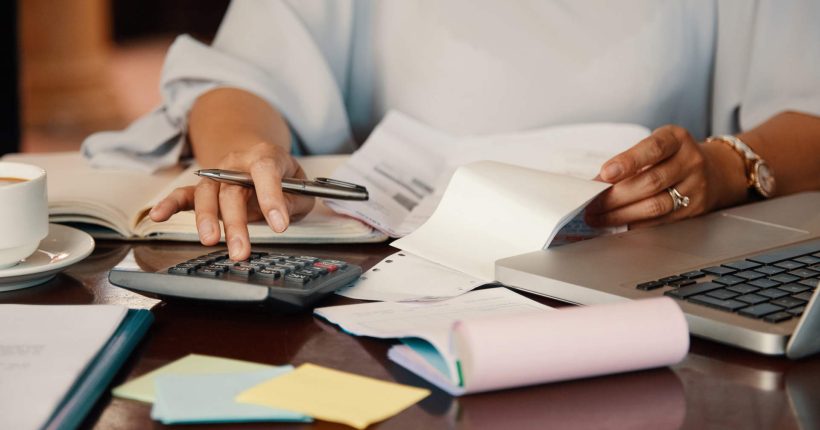 Hands of female entrepreneur working with bills and documents